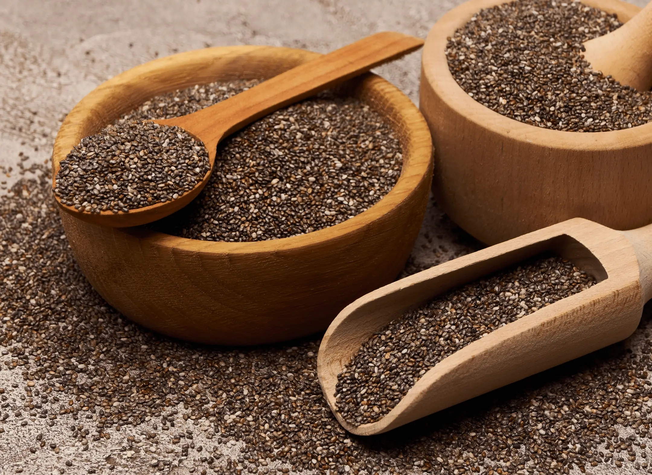 Chia seeds in wooden bowls and a scoop